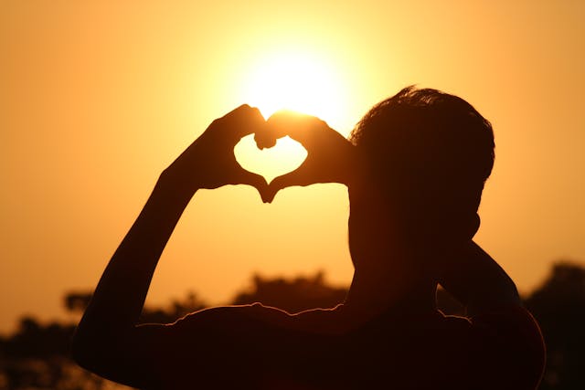 silueta de un hombre haciendo un corazón con las manos